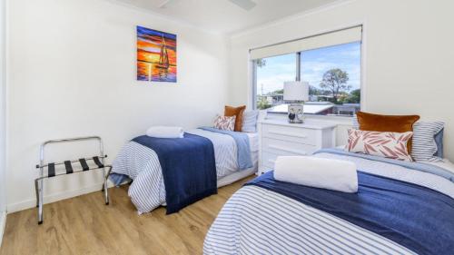 two beds in a room with a window at Fishing and Swimming at your doorstep - Sylvan Beach Esp, Bellara in Bellara