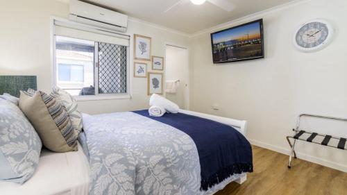 a bedroom with a bed and a clock on the wall at Fishing and Swimming at your doorstep - Sylvan Beach Esp, Bellara in Bellara