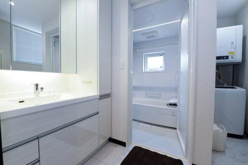 a white bathroom with a sink and a mirror at 手稲本町一軒家 in Sapporo