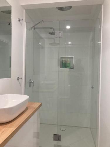 a bathroom with a sink and a glass shower at Rosewhite House in Myrtleford