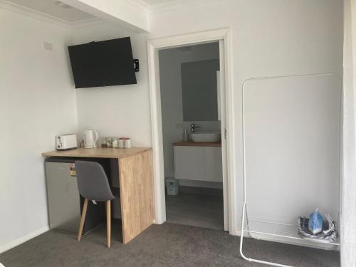 a room with a desk with a chair and a sink at Rosewhite House in Myrtleford