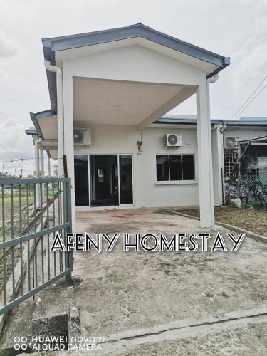 a small house with a warranty sign in front of it at Afeny Homestay in Tawau