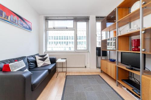 a living room with a couch and a tv at Shiny 1BR Flat in Fitzrovia, 2 min to Tube in London
