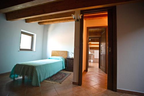 a bedroom with a bed with a green blanket on it at Agriturismo Miracco Atanasio Franco "Il Maniero" in Santa Sofia dʼEpiro