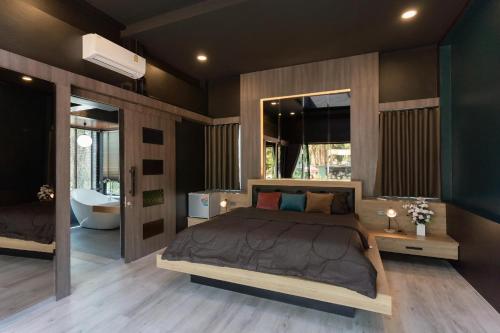 a bedroom with a large bed and a bathroom at Huather villa & cafe หัวเท่อวิลล่า in Ban Hin Sam Kon