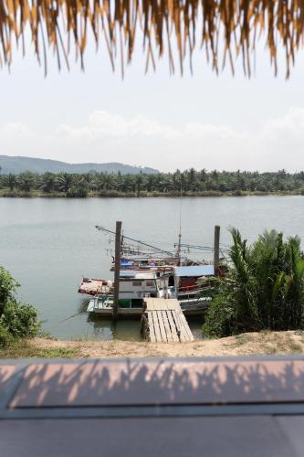 a boat docked at a dock on the water at Huather villa & cafe หัวเท่อวิลล่า in Ban Hin Sam Kon