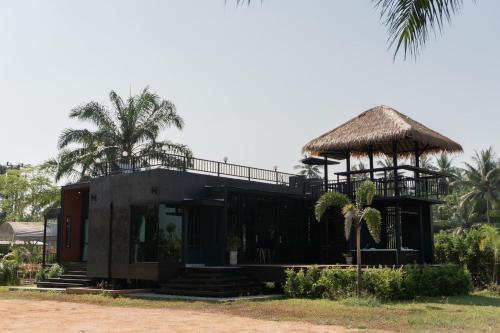 a house with a thatch roof and a porch at Huather villa & cafe หัวเท่อวิลล่า in Ban Hin Sam Kon