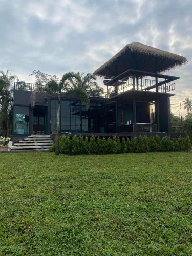 a building with a grass roof on top of a field at Huather villa & cafe หัวเท่อวิลล่า in Ban Hin Sam Kon