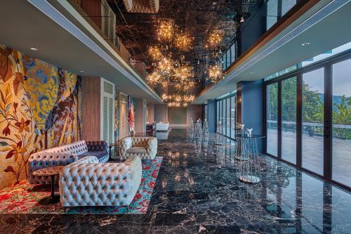 a lobby with couches and chairs in a building at Angsana Teluk Bahang, Penang in Batu Ferringhi