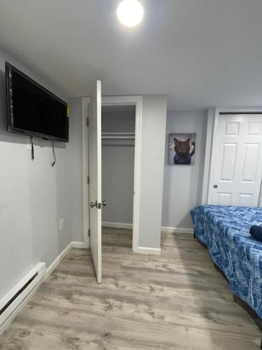 Schlafzimmer mit einem Bett und einem Flachbild-TV in der Unterkunft SUITE DREAM SHERMAN Room 23 in Passaic