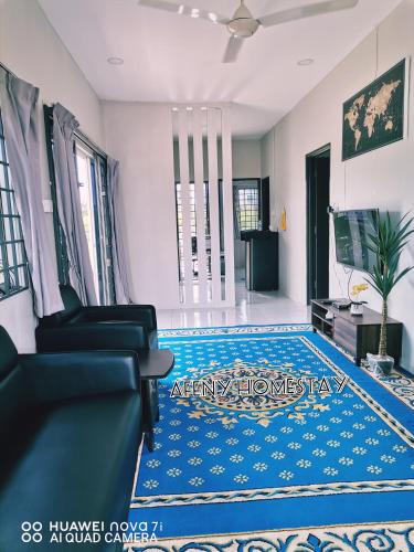 Afeny Homestay في تاواو: غرفة معيشة مع أريكة وسجاد أزرق