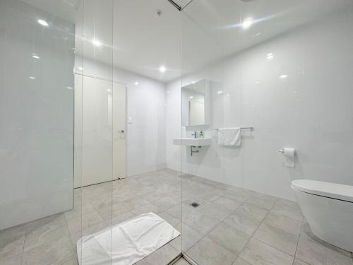 a bathroom with a shower and a toilet and a sink at Burwood Cozy Apartment Free Parking in Sydney