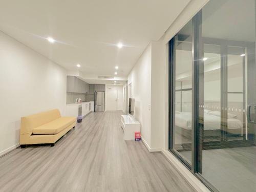 a living room with a couch and a bedroom at Burwood Cozy Apartment Free Parking in Sydney