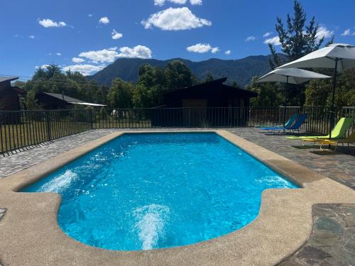 une piscine avec de l'eau bleue dans une cour dans l'établissement Rümü, à Pucón