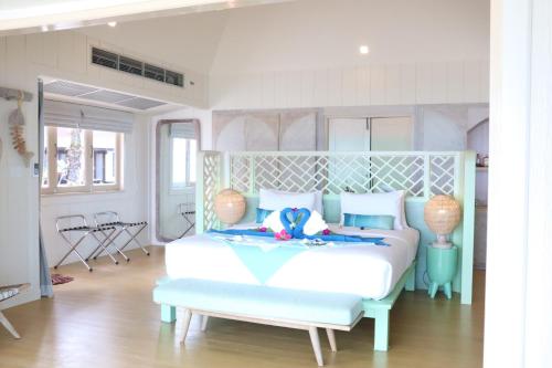 a bedroom with a white bed with a blue headboard at Koh Mook Sivalai Beach Resort in Koh Mook
