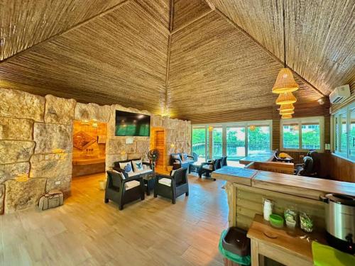 una gran sala de estar con una gran pared de piedra. en Caribbean Escape Lodge en San Silvestre