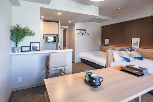 pokój hotelowy z łóżkiem i stołem w pokoju w obiekcie Apartment Hotel 11 Shinsaibashi III w Osace