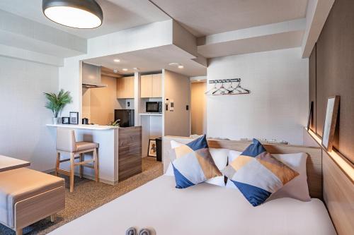 mały pokój z łóżkiem i kuchnią w obiekcie Apartment Hotel 11 Shinsaibashi III w Osace