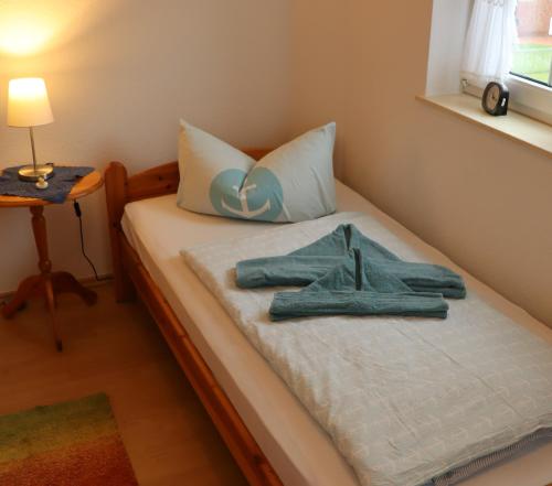 uma cama com duas toalhas em cima em Ferienhaus Inselblick em Dornumersiel