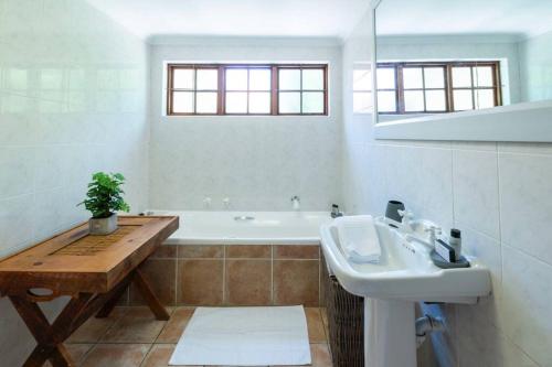 een badkamer met een wastafel en een bad bij Spacious family Home in Constantia with Pool in Kaapstad