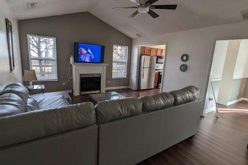 a living room with a leather couch and a fireplace at Haven - Uptown/Airport Corridor in Charlotte