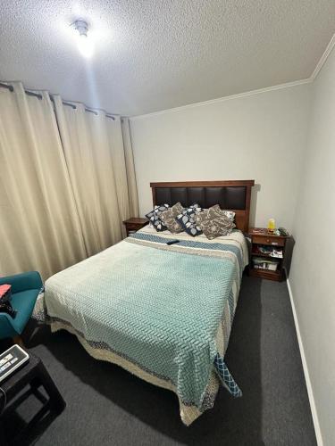 1 dormitorio con 1 cama con edredón verde en A pasos del aeropuerto, en La Serena