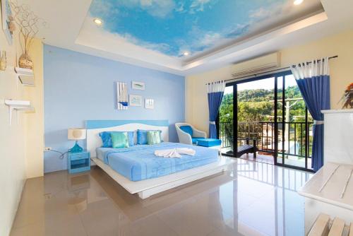 a blue bedroom with a bed and a balcony at KRABI MORE HOTEL in Klong Muang Beach