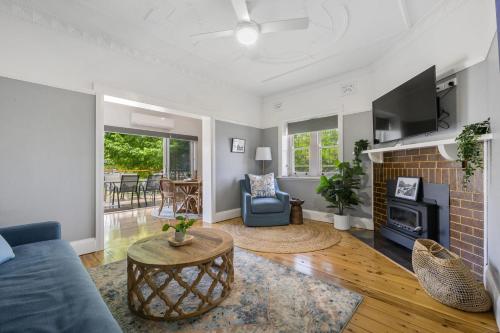 a living room with a couch and a fireplace at Bluestone Cottage - Character & Class in Orange