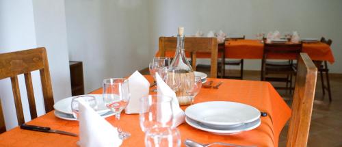 a table with wine glasses and plates on it at Agriturismo Miracco Atanasio Franco "Il Maniero" in Santa Sofia dʼEpiro