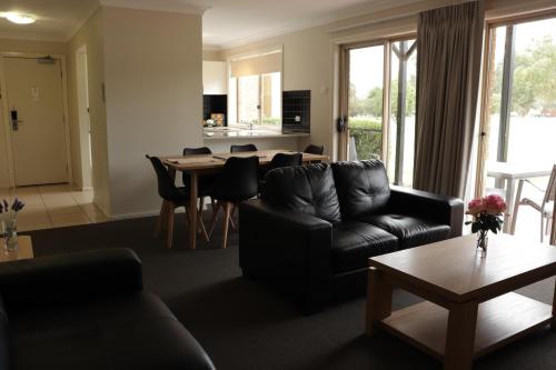 uma sala de estar com um sofá e uma mesa em Cootamundra Heritage Motel & Apartments em Cootamundra