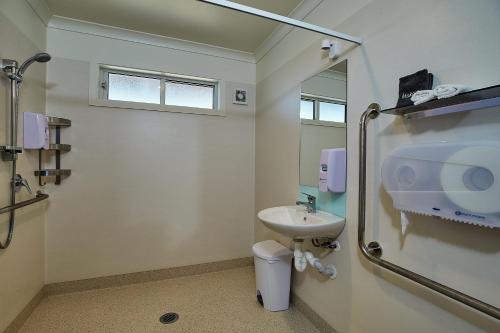 a bathroom with a sink and a toilet and a mirror at Kakatu Retreat Bed & Breakfast in Kaikoura