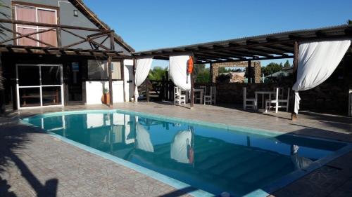a swimming pool with a patio and a house at Cabañas Sangiovese San Rafael in San Rafael