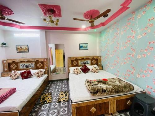 two beds in a room with blue walls at Shree Avantika home stay in Ujjain