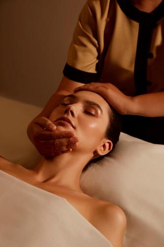 a man getting his head examined by a woman at Angsana Teluk Bahang, Penang in Batu Ferringhi