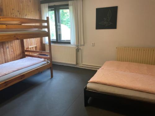 a bedroom with two bunk beds and a window at Chata Barbora in Lučany nad Nisou