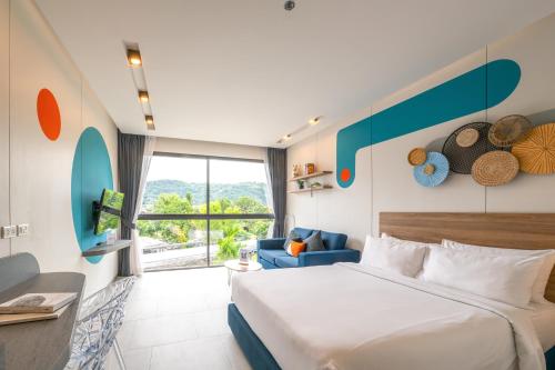 um quarto de hotel com uma cama e um sofá em HOMA Phuket Town em Cidade Phuket