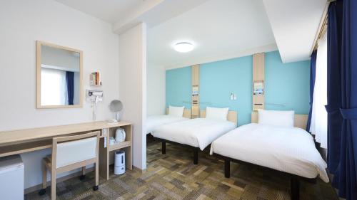 two beds in a room with a mirror at Toyoko Inn Gotemba Ekimae in Gotemba