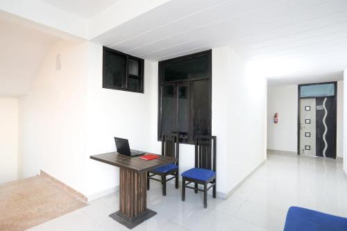 a room with a desk with a laptop and two chairs at OYO Flagship 61722 Rajmahal Residency Hotel in Bhiwadi