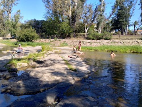 un grupo de personas nadando en un río en INTI naile en Villa Carlos Paz