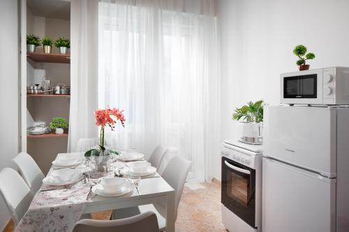una cucina bianca con tavolo e frigorifero bianco di National Palace of Culture 1 step away! a Sofia