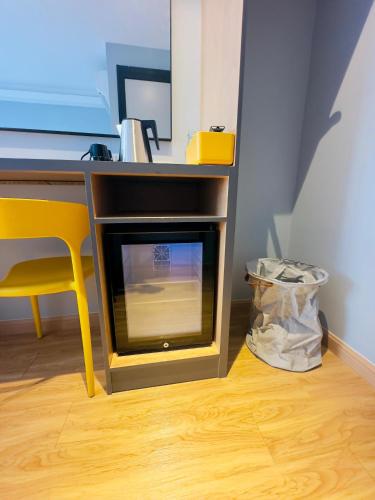 a desk with a fireplace next to a yellow chair at Blue Lagoon At Bandar Sunway in Petaling Jaya