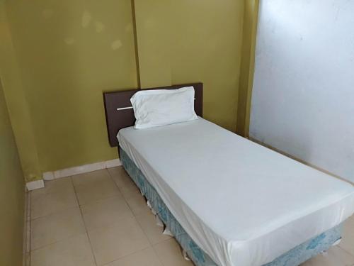ein kleines Schlafzimmer mit einem Bett in einem Zimmer in der Unterkunft SPOT ON 93464 Penginapan Tulimario Syariah in Jambi