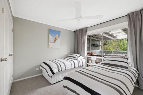 a bedroom with two beds and a window at Peppermint Lookout in Kilcunda