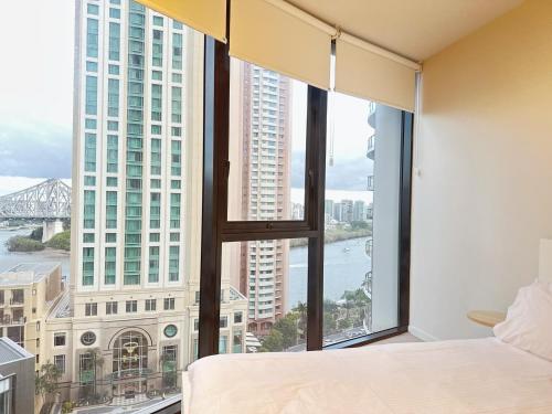 a bedroom with a large window with a view of the river at Riverside Story Retreat at Queen Street in Brisbane