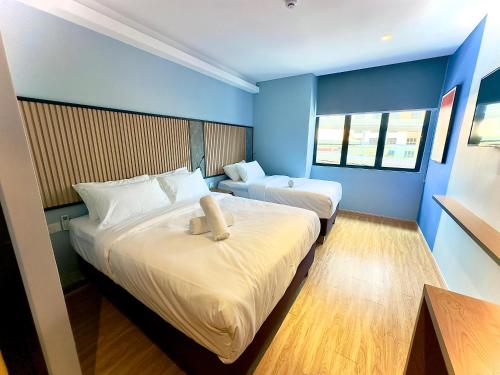 two beds in a room with blue walls at Blue Lagoon At Bandar Sunway in Petaling Jaya