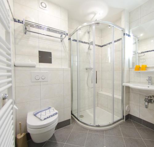 a bathroom with a shower and a toilet and a sink at Hotel Rosner in Gablitz