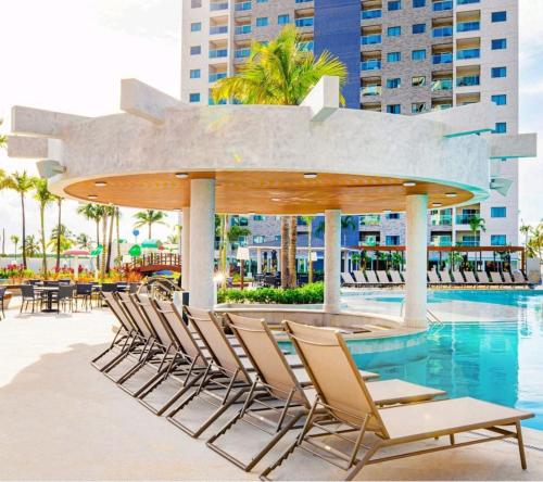 a group of chairs sitting around a swimming pool at Salinas Exclusive Resort in Salinópolis