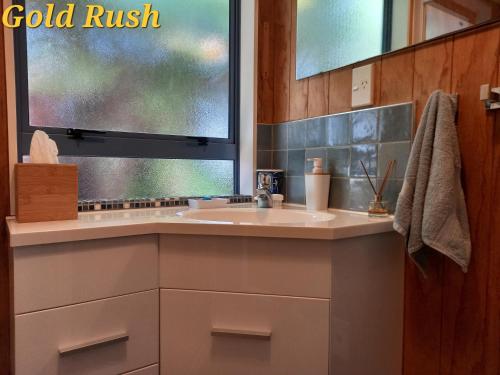 ein Bad mit einem Waschbecken und einem Fenster in der Unterkunft Charleston Goldfields Accommodation in Charleston