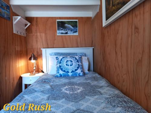 a bedroom with a bed with a blue comforter at Charleston Goldfields Accommodation in Charleston