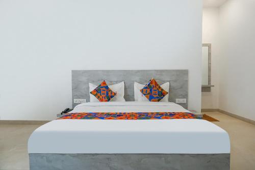 - une chambre avec un grand lit blanc et des oreillers colorés dans l'établissement FabHotel Irra Executive, à Pune